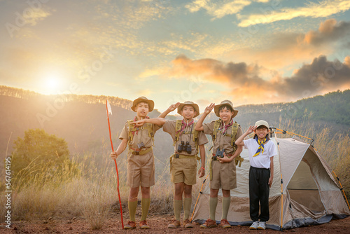 Quadro su tela Asian Boy Scouts Boy and girl making boy scout emblem in boy scout style or saluting and having good teamwork in school camp with mountain and tent background