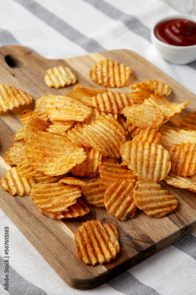 Barbeque Potato Chips on a wooden board, side view. Barbeque Potato Chips on a wooden board, side view.