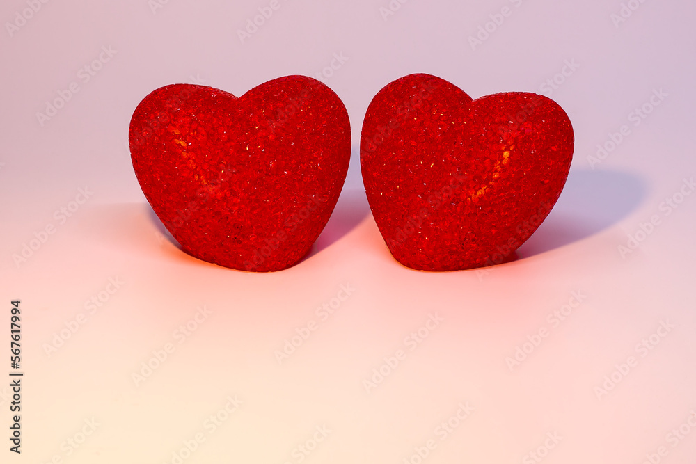 Fototapeta premium Two red hearts on a pink background