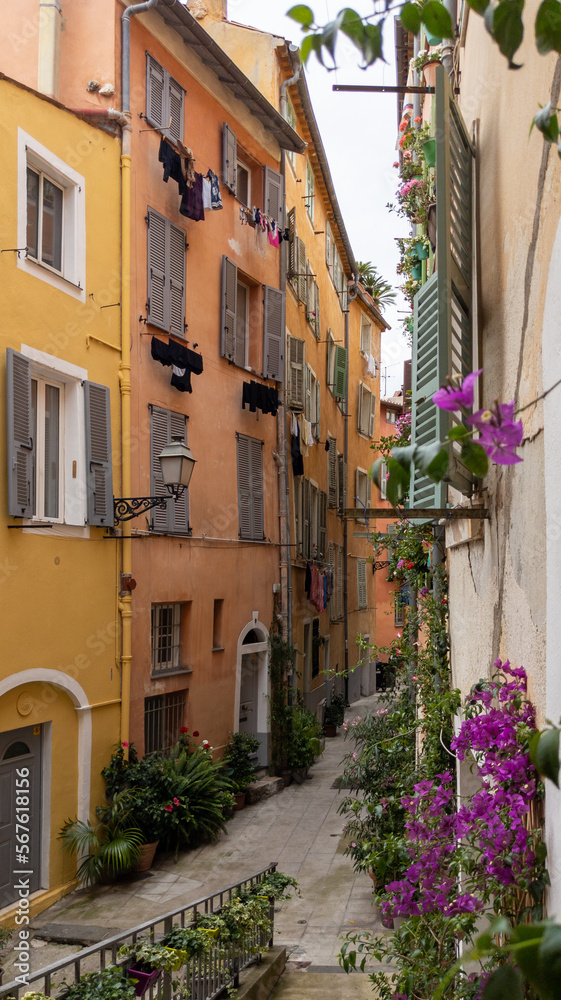 Old town street flowers in alley facade building architecture of Nice on French Riviera