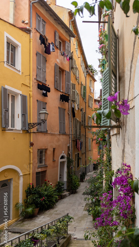 Fototapeta Naklejka Na Ścianę i Meble -  Old town street flowers in alley facade building architecture of Nice on French Riviera
