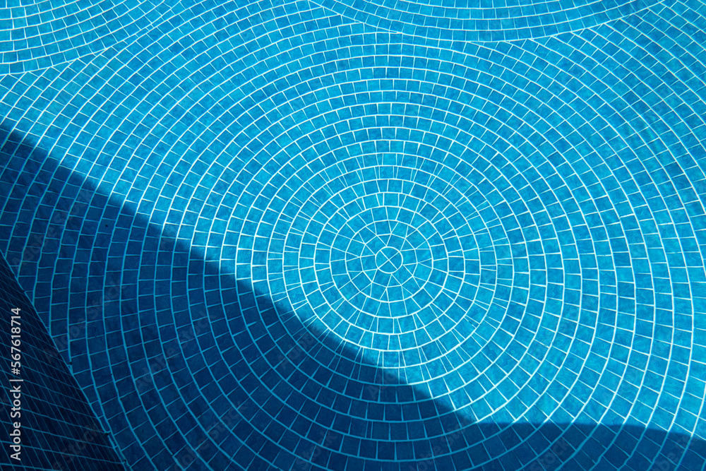 Swimming pool blue tiles textured background with sun light and shadow shade for summer vacation scenery Swimming pool blue tiles textured background with sun light and shadow shade for summer vacation scenery
