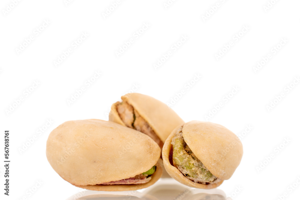 Three unpeeled pistachios, close-up, isolated on white. Three unpeeled pistachios, close-up, isolated on white.