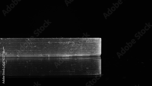 Side view of clear, transparent selenite shard as it pans across a black background, studio-lit for maximum clarity. Macro lens. photo