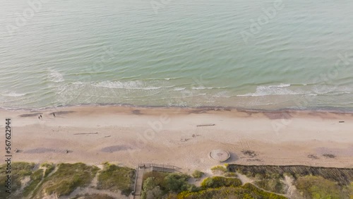 An aerial view The water of the Baltic Sea washes the beach where people walk on a quiet autumn afternoon. photo