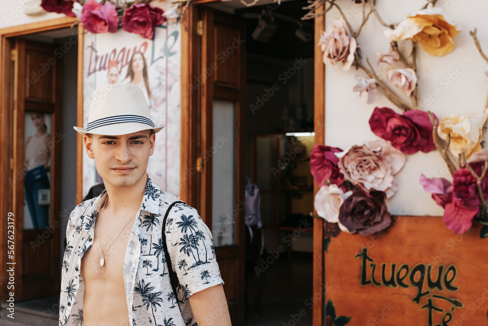 Portret młodego chłopaka w słomianym kapeluszu oraz rozpiętej koszuli w wakacyjny wzór, La Gomera - obrazy, fototapety, plakaty 
