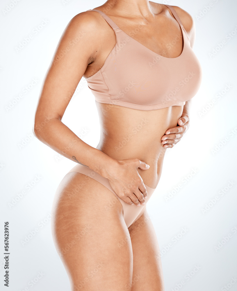 Woman, underwear and stomach hands on isolated studio background in workout, training or body exercise progress. Fitness, lingerie and model in tummy tuck, healthcare wellness or liposuction success