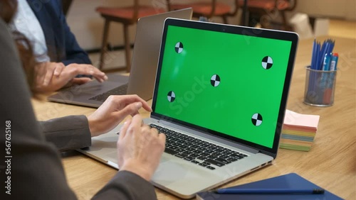 Colleagues in the office work on laptops. A woman and a man type, scroll, press keyboard keys and use a touchpad. Woman conducts business correspondence, manages the business. Close-up. Green screen.