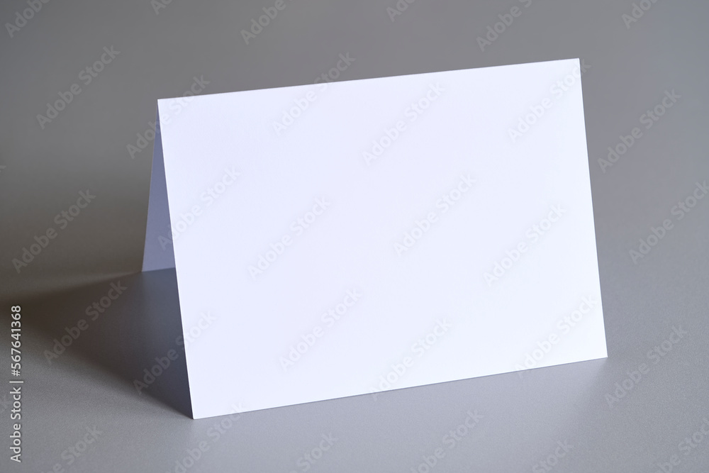 Standing blank empty rectangular greeting card mock up on grey background. For use as a Christmas, birthday, wedding or celebration background template. Standing blank empty rectangular greeting card mock up on grey background. For use as a Christmas, birthday, wedding or celebration background template.