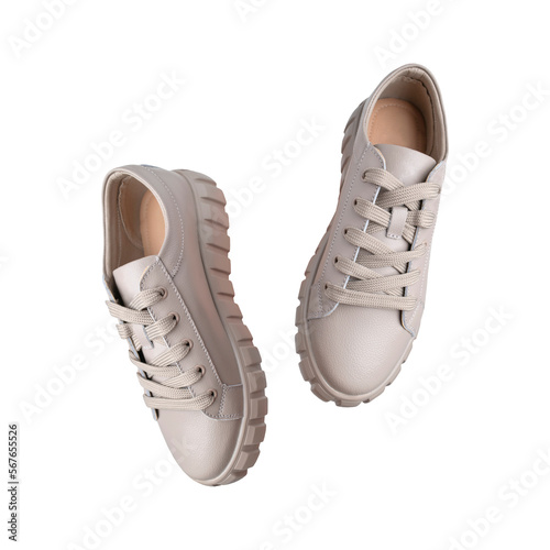 Beige gray leather female sneakers with lace isolated on white background. With clipping path. Flying fashion casual sneakers, sports unisex clothing shoes. Minimal mockup with footwear