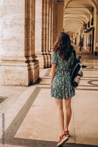 A beautiful woman walks with backpack in Turin, Italy.