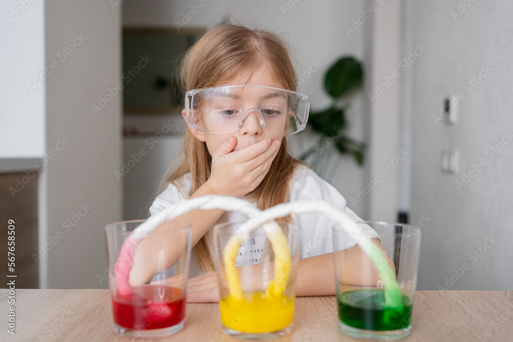 kid doing an experiment with coloured water. concept of learn from home, child STEM education and science for kid. kid doing an experiment with coloured water. concept of learn from home, child STEM education and science for kid.