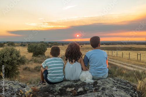 Fotografija Three friends looking the sunset in a summer day