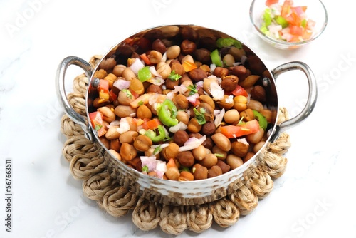 High in protine boiled black chana or chickpea salad. Chopped tomatoes, onion, chilies, and coriander mixed with boiled peanuts or bengal gram. Weight loss meal. Served with Lemon. Copy space. photo