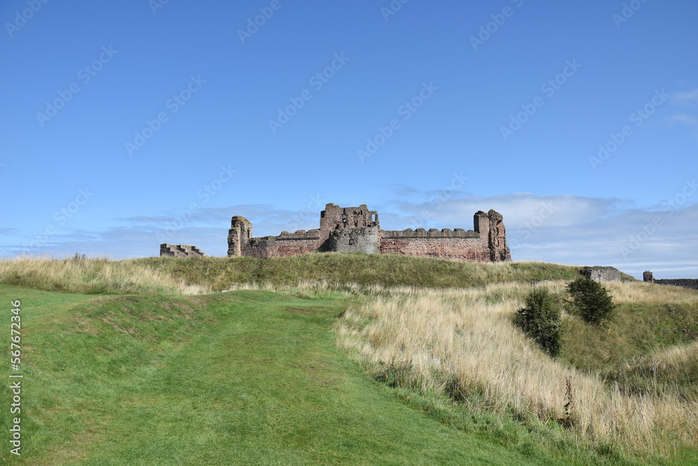 Tantallon castle exterior with green grass and a blue sky background. North Berwick Scotland. 