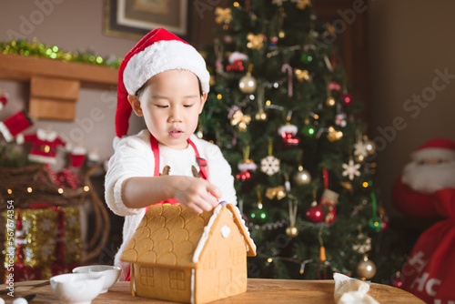 young girl making gingerbread house at home