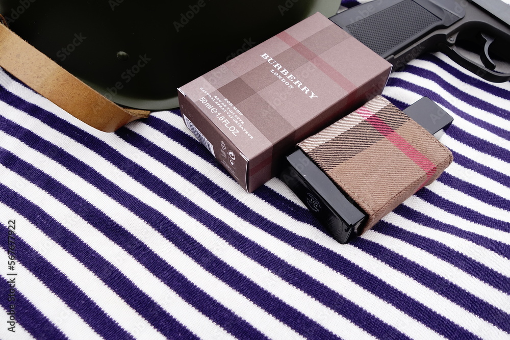 Fototapeta premium Bottle of Burberry London eau de toilette with a 1960s steel helmet and other Russian militaria, Taldom, Russia - October 31, 2020