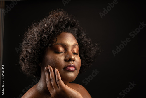 beautiful curvy girl with makeup touching her smooth face by cream health and beauty