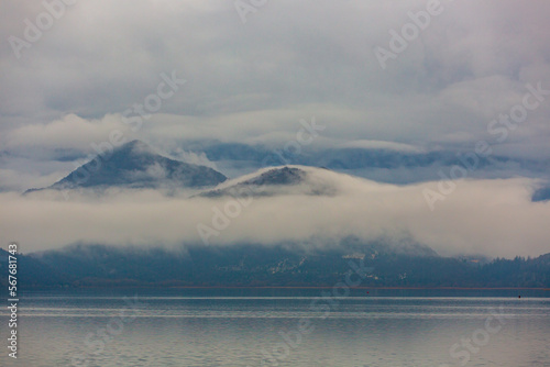 Mountains above the lake, shrouded in mist and clouds. Clouds, rain, autumn