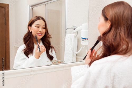 Wallpaper Mural Smiling asian woman doing make-up in bathroom Torontodigital.ca