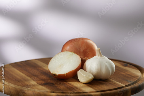 onions and garlic on a cutting board. a clove of garlic and half an onion lie with the whole. vegetables ready for cutting close-up. kitchen on a sunny day. High quality 4k footage