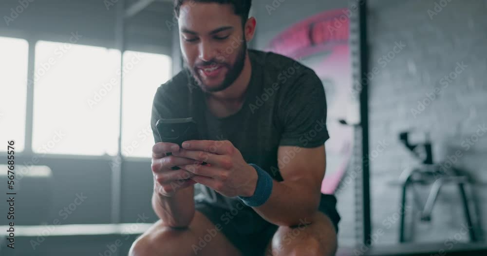 Phone, fitness and man relax in gym tracking workout, exercise or progress on break. Technology, sports and happy male with mobile smartphone for internet browsing, text messaging or social media.