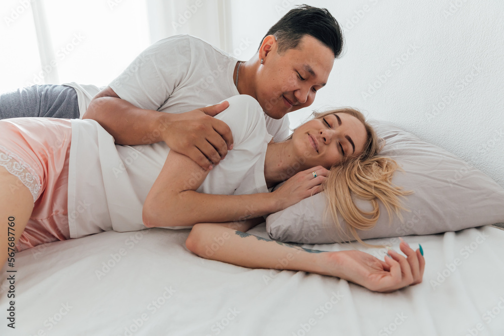 husband and wife man and woman lovers hug in the morning on the bed in the bedroom husband and wife man and woman lovers hug in the morning on the bed in the bedroom