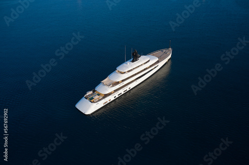 White mega yacht at sunset top view. Large innovative modern yacht anchored in the open sea aerial view. © Berg