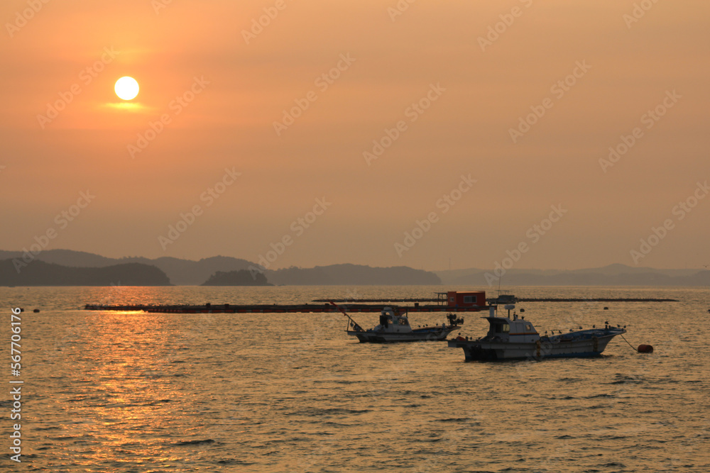 A fishing boat returning from the sea at sunset.