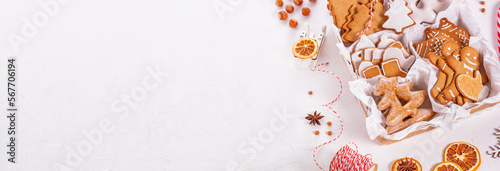 Top view of unpacked christmas present with sweets on a white textured surface, banner, close-up. Christmas celebration concept with space for text