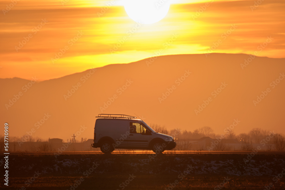 Small cargo van driving on highway hauling goods. Delivery transportation and logistics concept Small cargo van driving on highway hauling goods. Delivery transportation and logistics concept