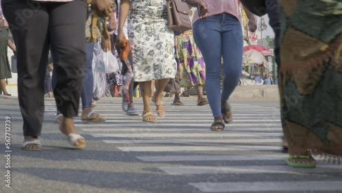 Ghana, February 2023 People walk across the road at Zebra markings.