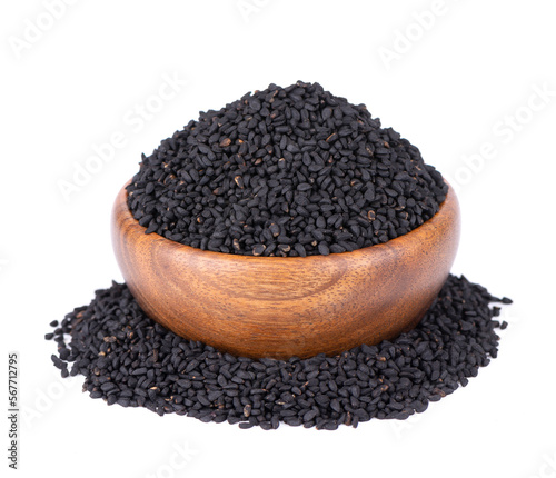 Black cumin seeds in wooden bowl, isolated on white background. Heap of black nigella seeds. Nigella sativa.
