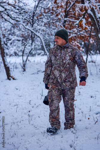 a male photographer in camouflage clothes in a winter landscape