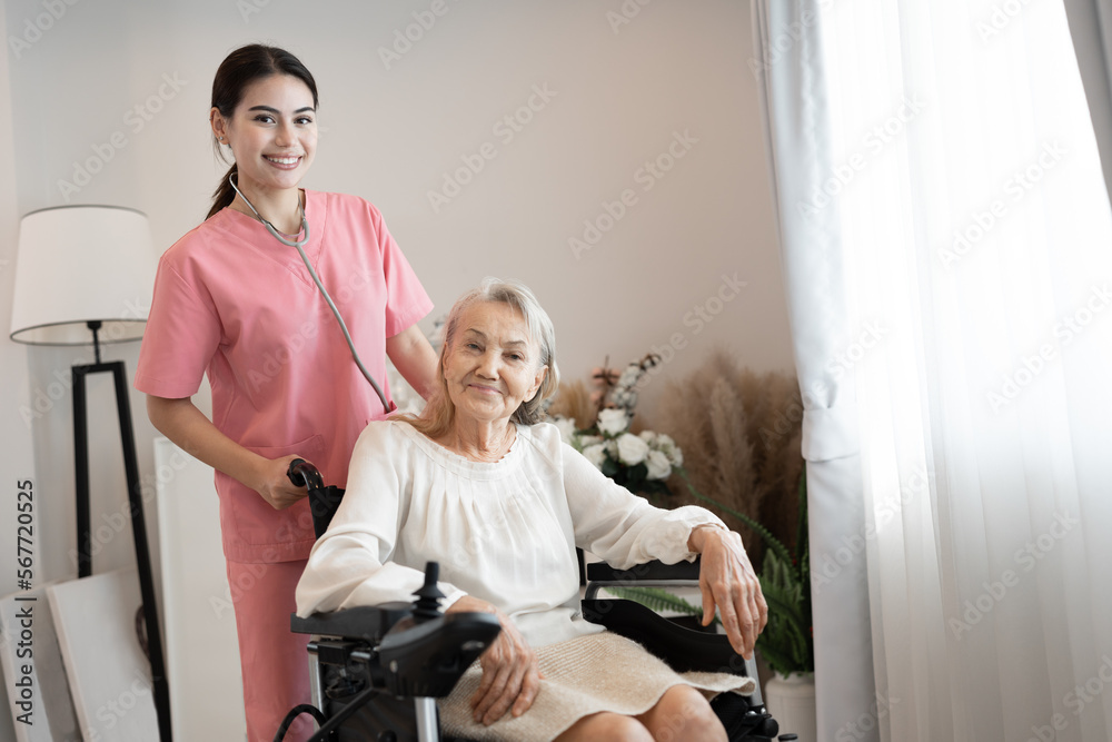 Happy caucasian nurse take care caucasian older woman on wheelchair at home	