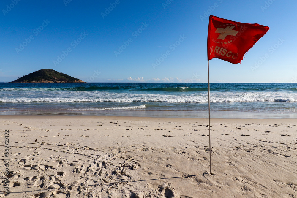 Rio de Janeiro, RJ, Brazil, 01/21/2023 - A red flag that indicates a high risk swimming spot at ocean on Grumari Beach 