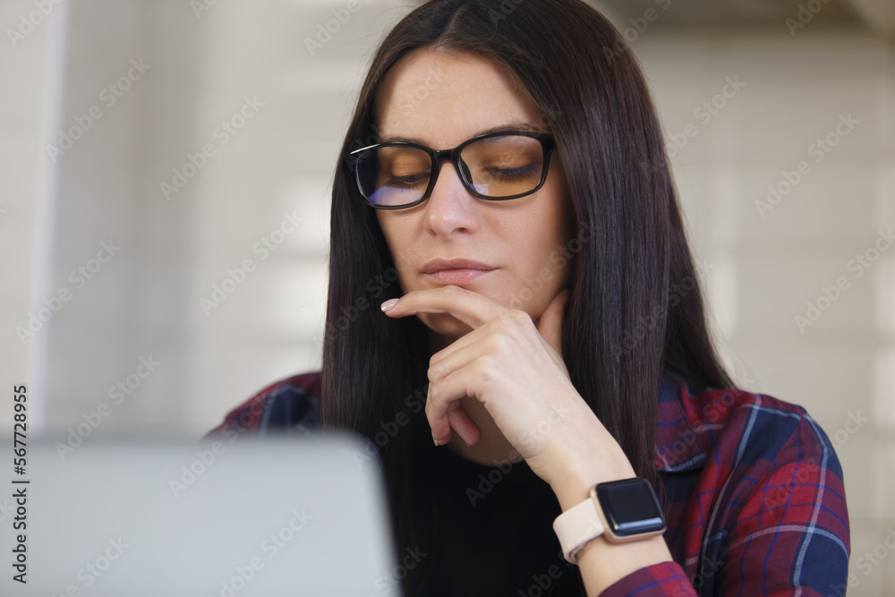 Young woman solving problems on computer. Portrait of focused white female person thinking about problem solution Young woman solving problems on computer. Portrait of focused white female person thinking about problem solution