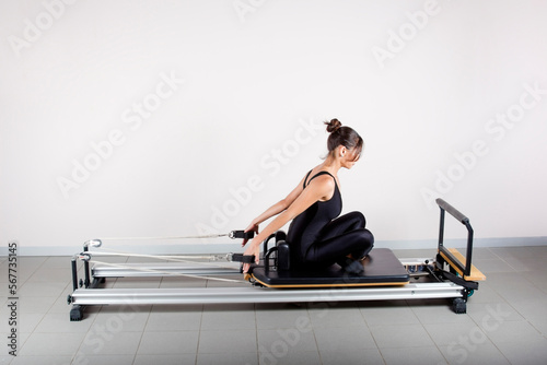 young woman doing pilates on a machine