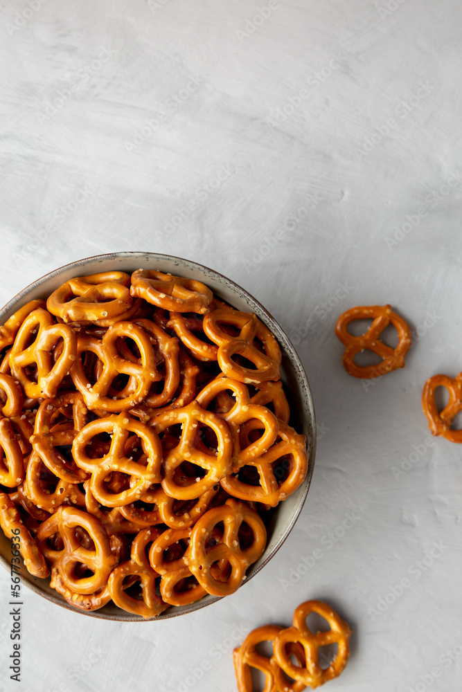 Mini Pretzels with Salt in a Bowl on a gray surface, top view. Flat lay, overhead, from above. Copy space. Mini Pretzels with Salt in a Bowl on a gray surface, top view. Flat lay, overhead, from above. Copy space.
