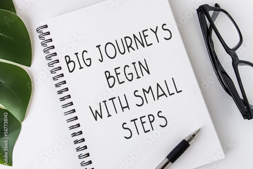 Big journeys begin with small steps. Text on notebook. Inspiring Creative Motivation Quote.