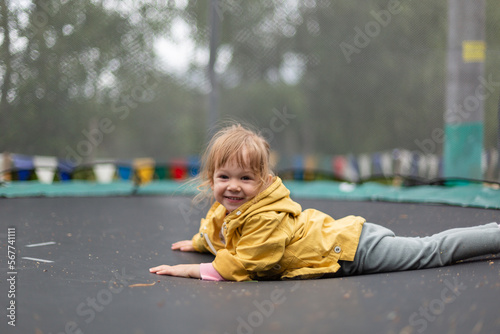 Little girl jumping on trampoline outdoors