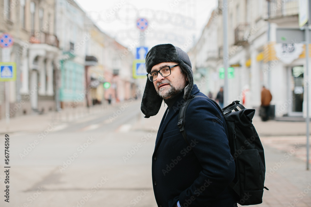 Senior man enjoying a walk in the winter city on the weekend. The concept of city life and recreation. Senior man enjoying a walk in the winter city on the weekend. The concept of city life and recreation.