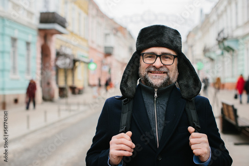 Senior man enjoying a walk in the winter city on the weekend. The concept of city life and recreation.