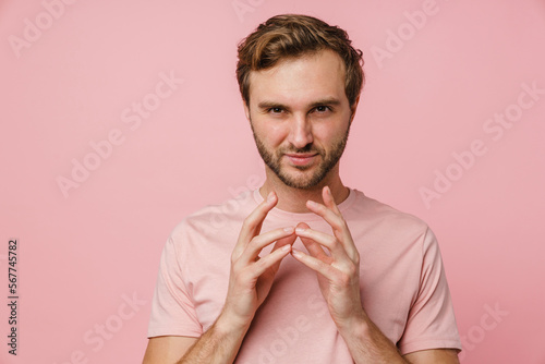Fotografie Tricky man clasping hands isolated over pink wall