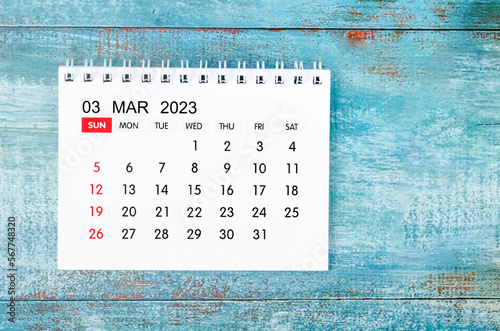 The March 2023 Monthly desk calendar for 2023 year on old blue wooden background. photo