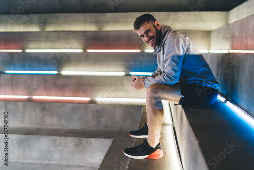 Smiling young man sitting on stairs in gym