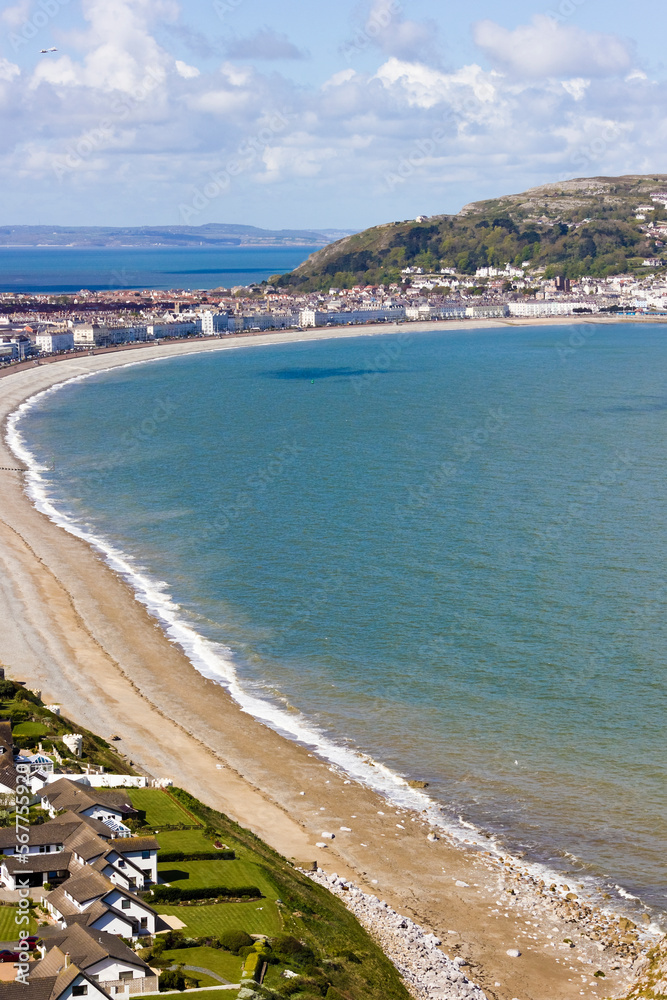 Portrait view looking across the bay at Llandudno towards a section of the curved Victorian promenade known as The Parade with the Great Orme in view, North Shore, North Wales