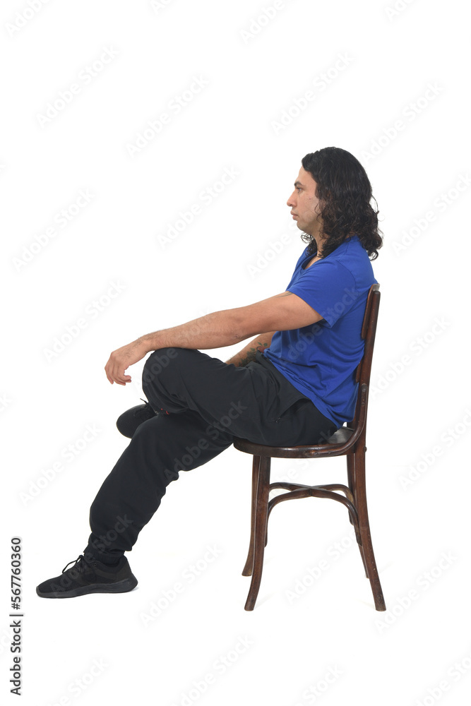 side view of a man with sportswear sitting on chair on white background