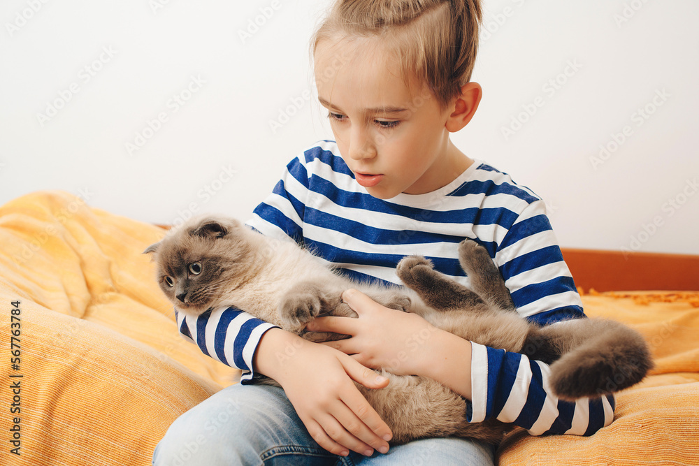 Happy kid hugging his cat. Boy relaxing on the bed with pet. Childhood, true friendship and home pet. Happy kid hugging his cat. Boy relaxing on the bed with pet. Childhood, true friendship and home pet.