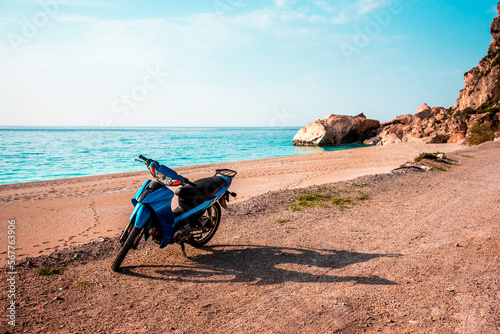 Obraz na płótnie Summer landscape with a blue scooter by the sea on a background of rocks. w salonie